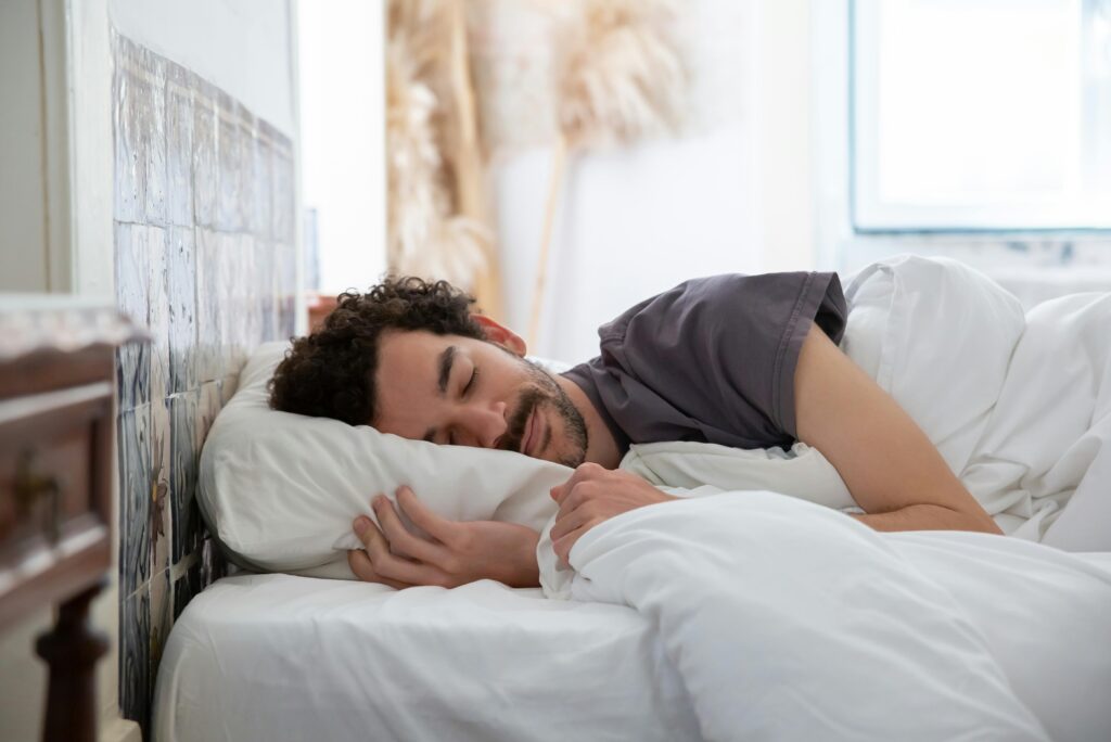 Man sleeping peacefully in comfortable bed demonstrating healthy sleep habits and evening routine
Better Sleep Through Evening Routine