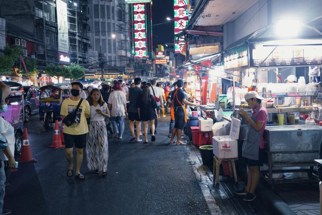 Busy night market in Bangkok with food stalls and people walking