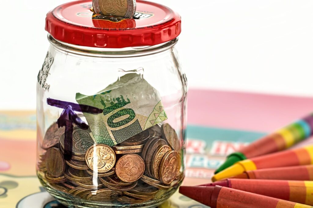  Person putting coins into a travel savings jar for a future trip
